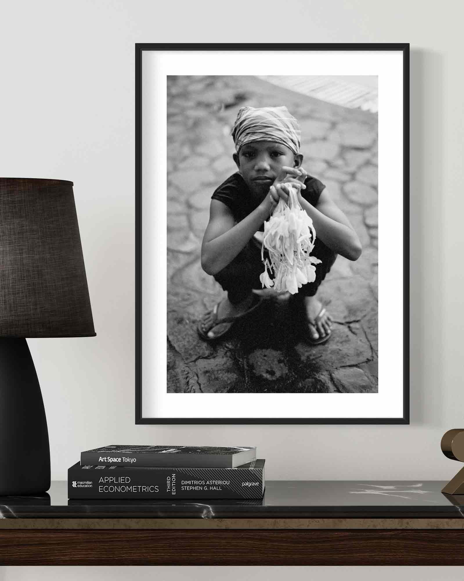 Framed Filipino boy portrait — a young sampaguita flower vendor with a direct gaze outside a church in Pampanga.