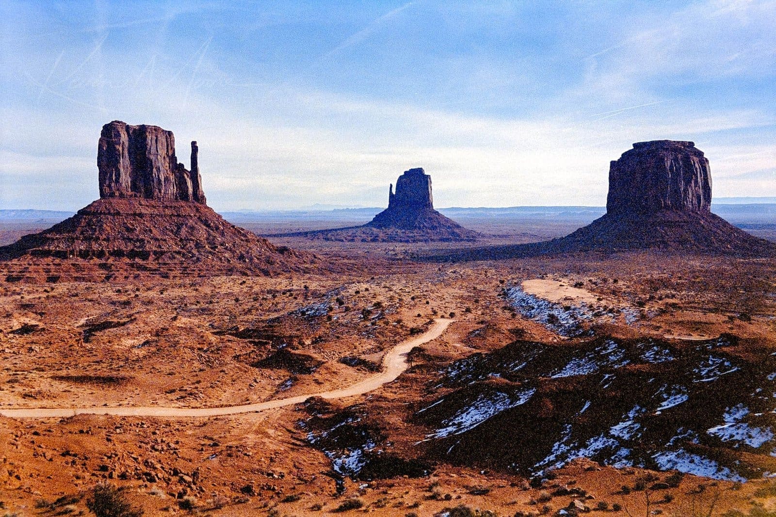 Iconic red sandstone buttes in Monument Valley under a clear gradient sky.
