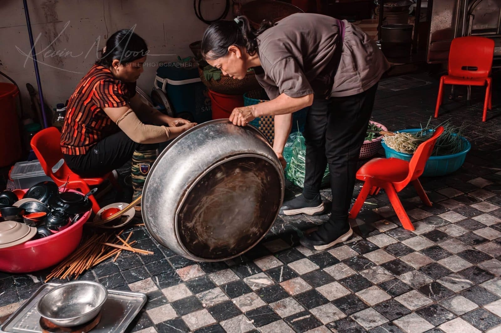 Two people preparing food in a rustic, traditional kitchen.
