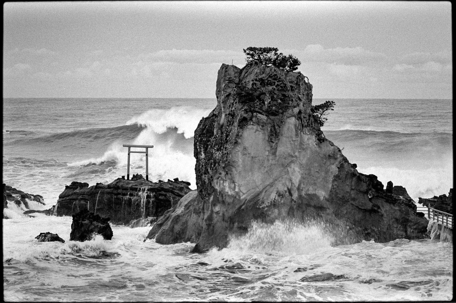 Japanese shrine print of the Bentenjima torii gate on a rocky outcrop as storm waves crash, Iwaki, Fukushima, Japan